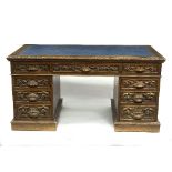 A carved oak pedestal desk, fitted nine drawers around a kneehole,