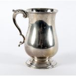 A silver mug, James Dixon & Sons, Sheffield 1945, of baluster form with leaf capped scroll handle,