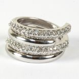 A diamond set interlocking ring to an unmarked white metal mount,