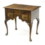 A George III walnut and featherbanded lowboy, on cabriole legs with bun feet,