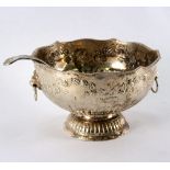 A large silver plated punch bowl and ladle, repoussé decoration of floral sprays,