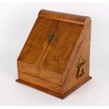 A Victorian oak and brass mounted stationery cabinet, with slope front and fitted interior,