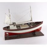 A model fishing boat on a stand with rigging, sails etc.