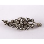 A diamond set floral brooch to an unmarked yellow metal mount,