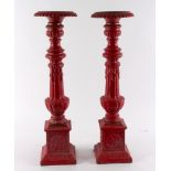 A pair of red painted cast iron pricket candlesticks,