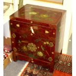 A 20th Century Chinese lacquered cabinet, decorated flowers to a red ground,