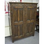 A carved oak cupboard, enclosed by two linenfold panel doors, 182.