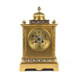 A late 19th Century French gilt brass and champlevé enamel mantel clock with gadrooned top and