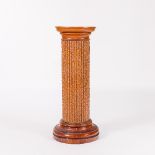 A majolica pottery jardinière stand, of column form with naturalistic moulding,