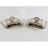 A pair of plated rectangular entree dishes and covers,