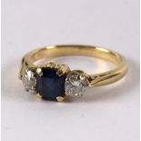 A sapphire and diamond set three-stone ring, the central step cut sapphire approximately 0.