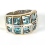 A blue topaz set dress ring, set ten square step cut graduated stones to an 18ct white gold mount,