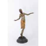 An Art Deco style figure, modelled as a dancer in costume, on integral circular base,