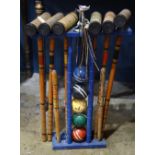 Vintage croquet set, having six sticks, five balls, and additional accessories, in a polychrome