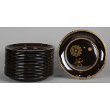 (lot of 20) Japanese black lacquered plates, the center with three stylized medallions, the rim