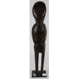 Makonde carved wood figure, the form with short arms, thin legs, and small feet turned inward,