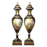 Pair of monumental Sevres style porcelain and bronze mounted urns, each having a finial capped lid