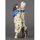 Japanese Satsuma ceramic figure, of a travelling entertainer with a bundle and a monkey on his