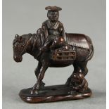 Japanese wood netsuke: depicting a traveler on horseback with children,