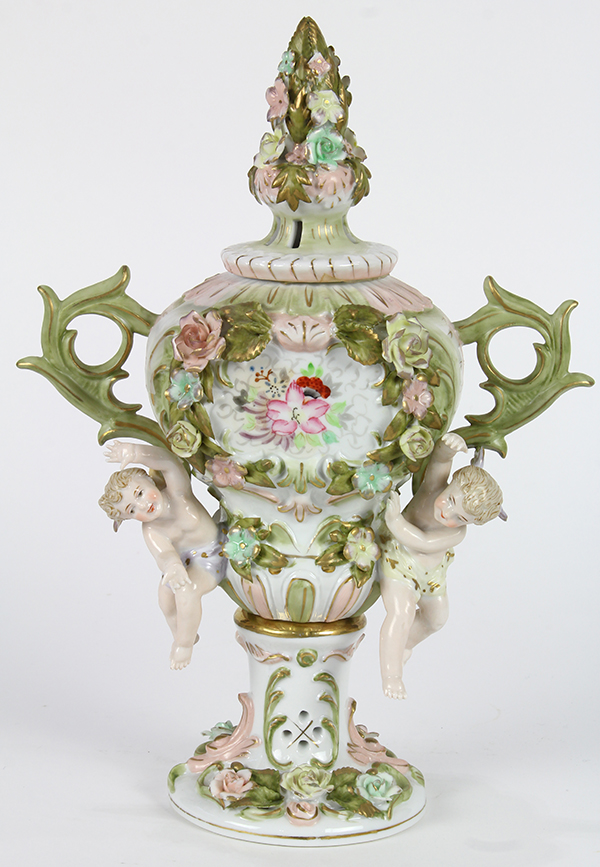 Continental porcelain lidded urn, the baluster form with floral finial flanked by foliate form