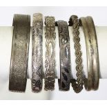 (Lot of 6) Silver bracelets comprised of one braided coil tension locking flower motif silver bangle