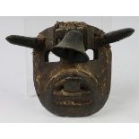 Small Mexican mask depicting a bull, probably 19th Century, with wood horns and a bell, showing