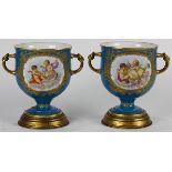 Pair of French Sevres style porcelain urns with "Bleu du Roi" ground and polychrome floral bouquet