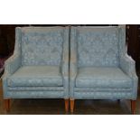 Pair of Mid-Century Modern style lounge chairs, each having light blue upholstery with a tufted