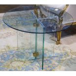 Modern glass coffee table, having a round tempered glass top above the X form glass base, 20"h x