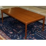 Mid-century teak coffee table, having a rectangular top and rising on tapering legs, 20"h x 4'7''w x