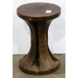 Indigenous style carved wood stool having a round seat resting on four shaped supports, 16"h x 11"w