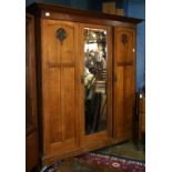 Arts and Crafts quartersawn oak panelled armoire, circa 1910, having a molded crestrail