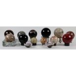 (Lot of 14) Stone specimens, each as a globe with polished surface and rising on a fitted base,