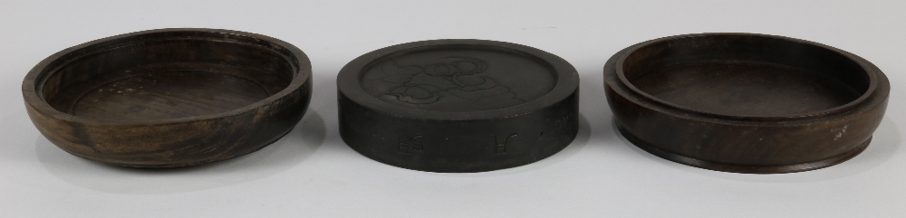 Chinese circular ink stone in wood box, the stone carved with scroll band to the rim and melons to