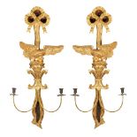 (lot of 2) Continental giltwood carved sconces, each having a ribbon finial, above the figural