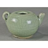 Chinese celadon glazed pouring vessel, the compressed body molded with a reed pattern and a short