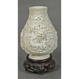 Chinese bisque hu form jar, molded and applied with dragon roundels accented by Daoist treasures,