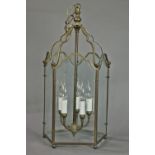 Georgian style brass lantern, having beveled glass panels surrounding five lights