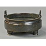 Chinese bronze tripod censer, with inverted U shaped handles at the rim, above the shallow