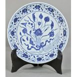 Chinese underglaze blue porcelain charger, decorated with floral spray in the well and scrolls on