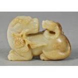 Chinese serpentine carving, of a cub on the back of a recumbent beast with a floral sprig in its
