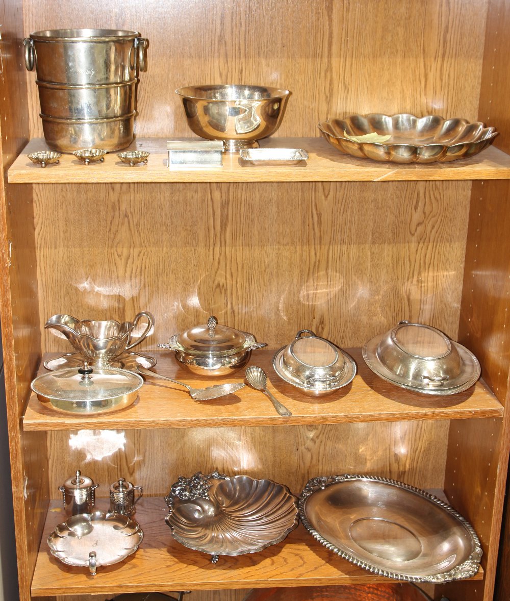 Three shelves of associated silverplate table articles, including salts, serving platters, tobacco