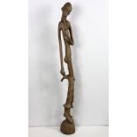 African figural statue, 20th Century, chipwood carved, depicting a weathered nude man spoking a