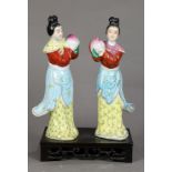 Pair of Chinese enameled porcelain figures, of celestial beauties each holding a peach, 12"h