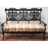 Renaissance Revival rosewood settee, having a pierced back accented with scroll and leaf accents,