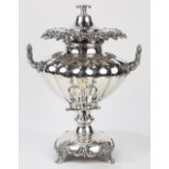 Ornate silverplate hot water urn, having a compressed pear form with applied handles decorated