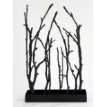 Patinated bronze sculpture, depicting naturalistic branches vertically oriented, rising from a