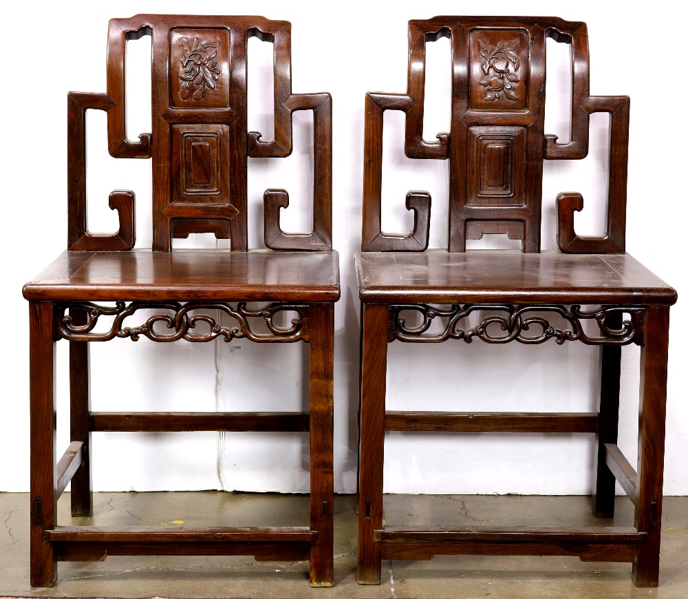 Pair of Chinese wooden side chairs, the stepped back inset with a panel carved with peaches, the