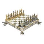 Giuseppe Vasari gilt metal chess set and board, circa 1965-1970, the fiugral pieces depicting the