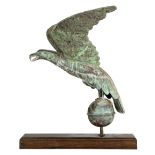 Patinated copper figural weathervane, depicting a flying eagle, rising on a sphere, continuing to